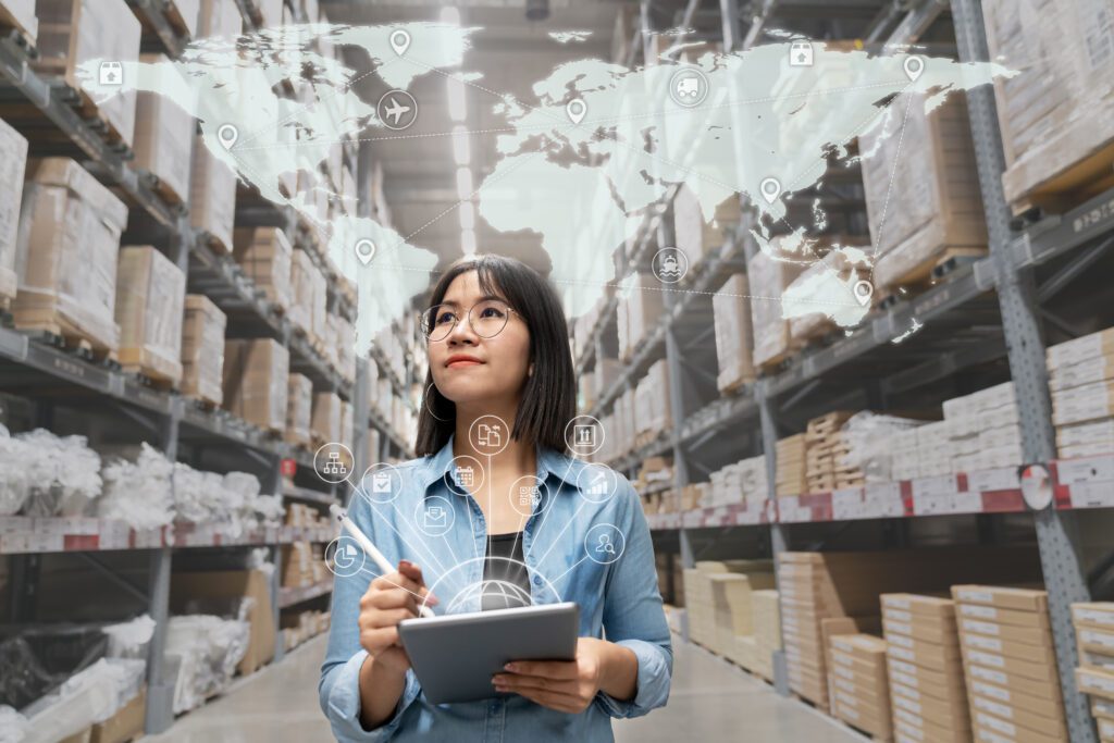 Portrait of happy young attractive asian entrepreneur woman looking at inventory in warehouse using smart tablet in management technology, interconnected industry, asian small business sme concept.